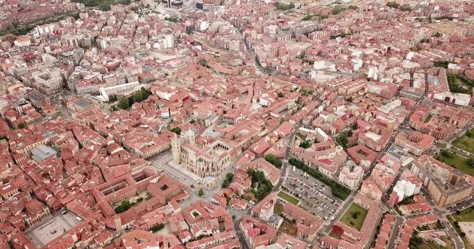 View from drone of reddish roofs of residential buildings and medieval Gothic Cathedral in Spanish city of Leon 