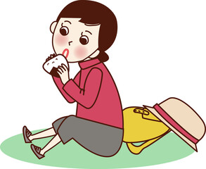 座っておにぎりを食べる女性。