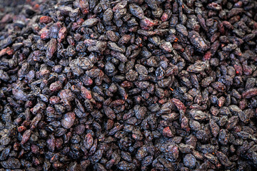 Close-up of purple raisins on a showcase in a supermarket, top view. Dried grapes