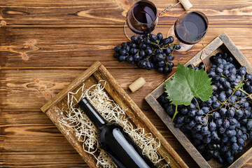 Red Wine composition on brown wooden table. Top view. Red wine bottle corkscrew corks wine glasses...