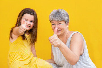 Grandmother and child show thumb up