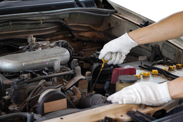 Fototapeta premium Auto mechanic checking the oil level in car engine,inspects engine water level dipstick,Check the dipstick in the car engine. 