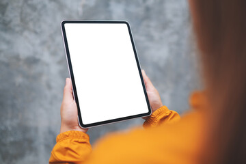Mockup image of a woman holding digital tablet with blank white desktop screen in the outdoors