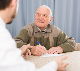 Old man and social department manager fill in questionnaire