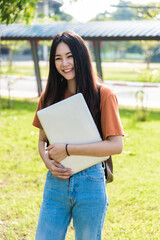 Fototapeta premium Young woman with backpack hold notebook standing in university
