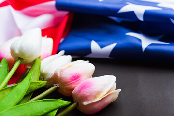 Happy Memorial Day Remember previously but now seldom called Decoration Day, American flag and a Tulip flower on a black background and copy space, a federal holiday in the United States