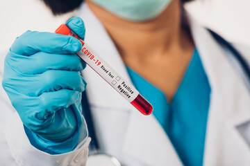 Doctor scientist in white uniform wear a mask holding test tube Coronavirus test blood sample in a clinical laboratory for analyzing isolated on white, medicine COVID-19 pandemic outbreak concept