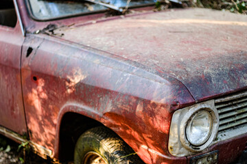 Rusty red abandoned car trunk detail completely damaged