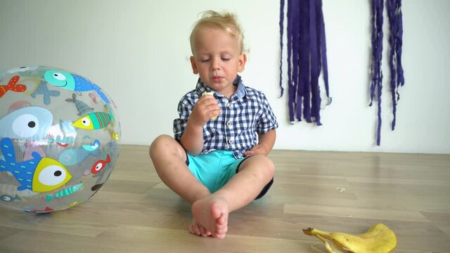 Handsome toddler in shirt is eats yellow banana. Stabilizer Gimbal motion