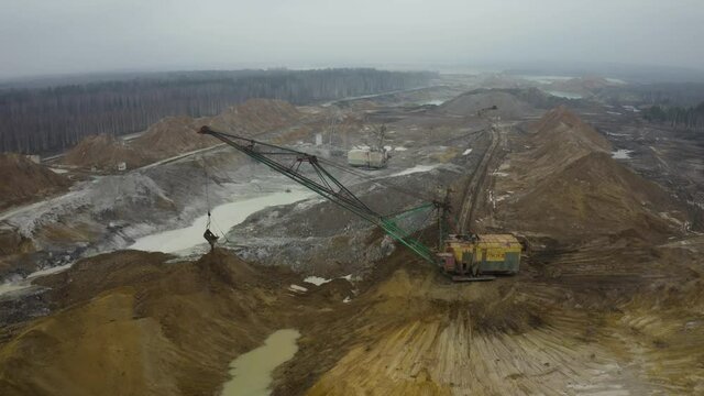 Aerial view of quarry with equipment. Quarry mine industry rock extraction heavy machinery equipment. Dragline Excavator Loads Soil, Clay. Dragline excavator in surface mine area with landscape. 