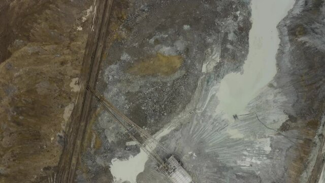 Aerial view of quarry with equipment. Quarry mine industry rock extraction heavy machinery equipment. Dragline Excavator Loads Soil, Clay. Dragline excavator in surface mine area with landscape. 