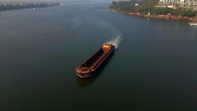 Sand cargoes sand ship crossing mandvi river goa india panji drone orbital shot 360 sunset shing on water
