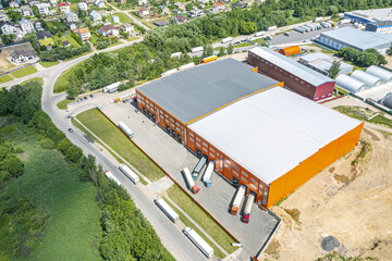 logistics center in urban industrial district from above. aerial view of goods warehouse and trucks.