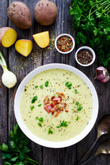 Cream potato soup with bacon on wooden table
