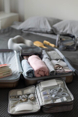 Suitcase technique wires equipment on bed. Package or storage with stuff, clothes and accessories