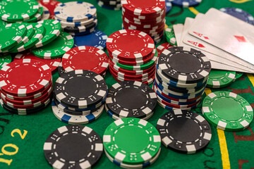 poker chips  with play cards on the green casino table