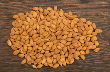 Top view dry nuts from an apricot kernel on a wooden table.