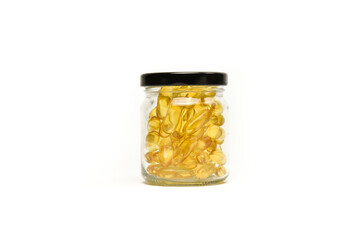 Close up of Gold fish oil in jar glass isolated for good health on white background view. Supplementary food. Omega 3. Vitamin E. Capsules salmon fish oil.