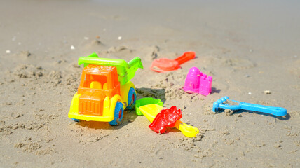 Fototapeta na wymiar Colorful kids toys for building sand castle, on a sandy beach,