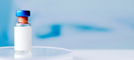 Ampoules in hand and syringe with Covid-19 vaccine on a laboratory table. For the prevention, immunization and treatment of coronavirus infection.Infectious medicine concept. copy space