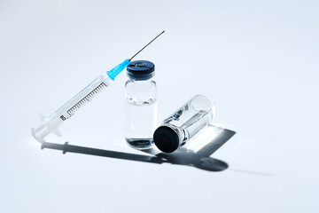 Close up glass vial with flu vaccine and syringe with needle. The concept of vaccination or...