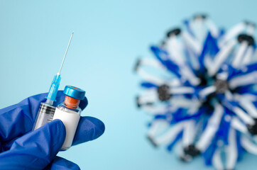 Ampoules in hand and syringe with Covid-19 vaccine on a laboratory table. For the prevention, immunization and treatment of coronavirus infection.Infectious medicine concept. copy space