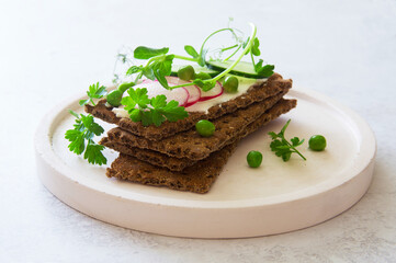 Healthy rye bread with raw spring vegetables close up