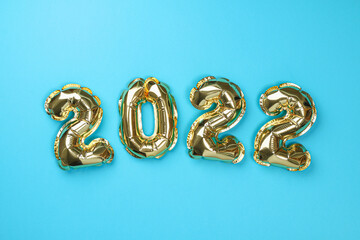 New Year 2022. Foil balloons numbers 2022 on a blue background. New Year Christmas.