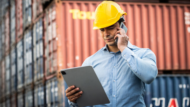 Caucasian Worker Use Smartphone And Ipad About Business Working At The Port For Transfer Products.