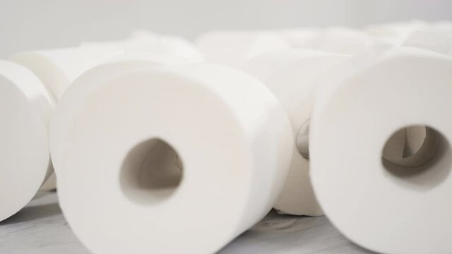 New white toilet paper rolls on a gray background.