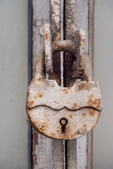 A dirty old lock covered with rust for barns and other doors