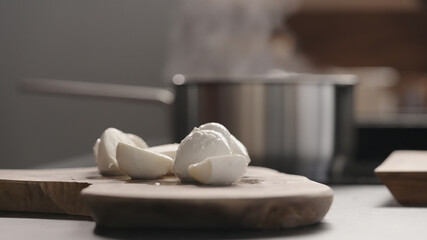 medium sized mozzarella balls on olive wood board