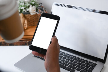 Close up view of linesman drinking coffee and using smart phone at office.