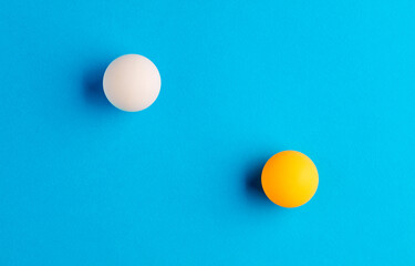 Two orange table tennis balls opposed to each other
