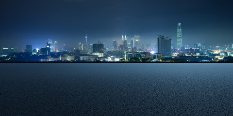 Empty asphalt floor with cityscape background