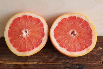 Naklejka na ściany i meble red grapefruit on wooden background, juicy and beautiful grapefruit