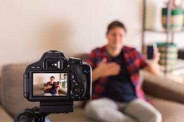 Vlogger recording social media video while sitting on the couch