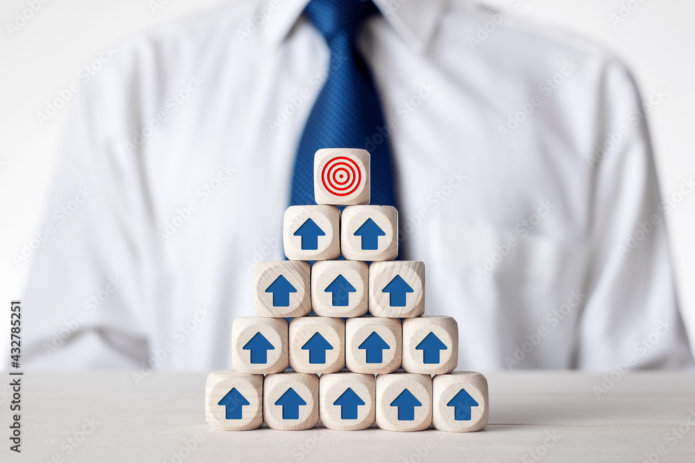 Poster tiered wooden cubes designed as organizational hierarchy with employee icons in front of a businessm