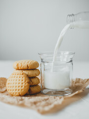 Delicious homemade peanut butter cookies with mug of milk, on white background. Healthy breakfast concept.