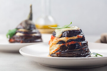 Italian dish. Parmigiana di melanzane - deep fried sliced eggplants baked with mozzarella, parmezan cheese and tomato sauce. Light background.