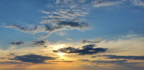 Fototapeta premium Beautiful golden sunset background in blue sky 