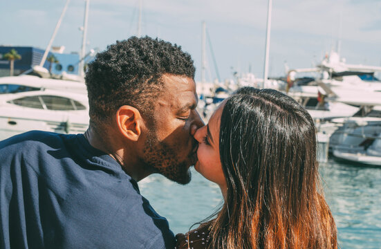 
Close up of Interracial Couple Kissing at the Port with Boats Background in Summer During Holidays