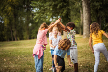 Fototapeta premium Large group of school kids having fun in nature. Playfully time.