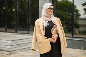 modern stylish muslim woman in hijab in city street