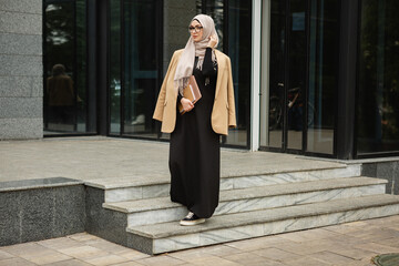 modern stylish muslim woman in hijab in city street