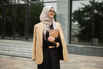 modern stylish muslim woman in hijab in city street