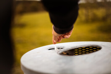 Man puts out a cigarette. Focus is on hand.  Let's preserve nature.