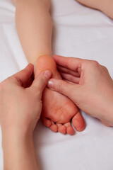 Doctor performing pediatric foot massage to prevent development of flat feet