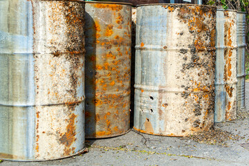 Close up of old rusty metal barrels with Sea Pocks, used as water buoys onshore