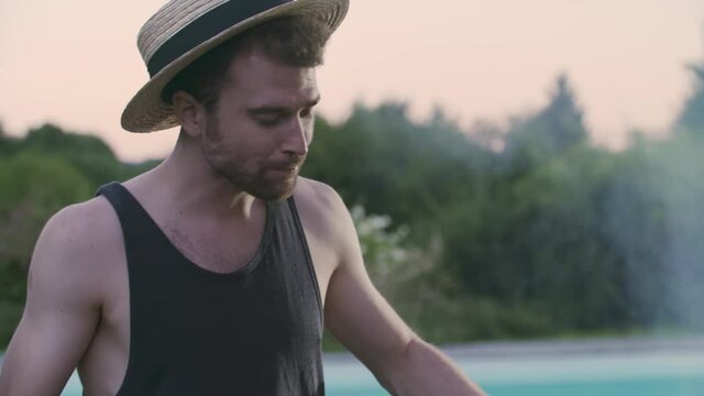 close up of smiling man with hat doing bbq. Summer, Spring break, friend, group, party, together, Man drinking fresh beee